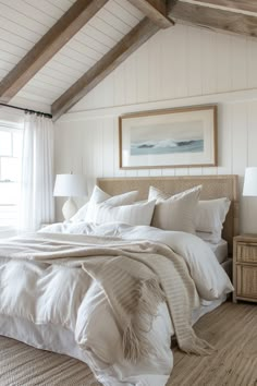 a bed with white sheets and pillows in a bedroom