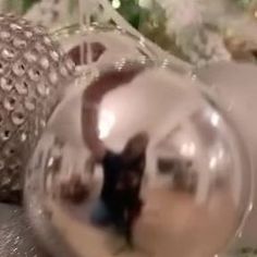 a glass ball ornament sitting on top of a table next to a christmas tree