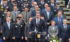 a group of men and women in suits standing next to each other at a podium