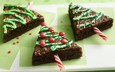 three pieces of brownie decorated with green icing and candy canes