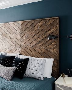 a bedroom with blue walls and wooden headboard