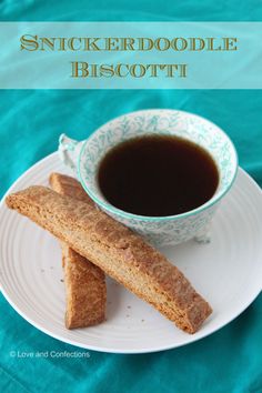 a white plate topped with two pieces of biscuit next to a cup of coffee