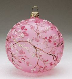 a pink glass ornament with flowers on it