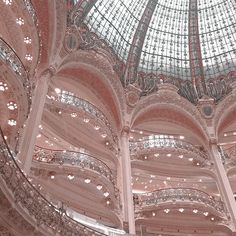 the inside of a large building with many windows and glass ceiling lights on each side