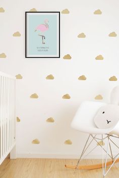 a white rocking chair in front of a wall with gold clouds and a pink flamingo