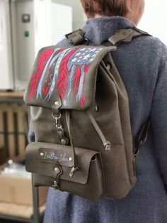 a woman wearing a backpack with an american flag design on the front and back pocket