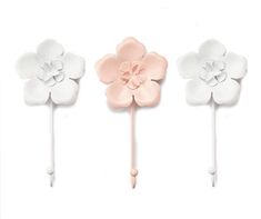 three white and pink flower shaped cake toppers on a long stick, one with a single flower in the middle