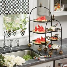 watermelon slices are arranged on trays in the corner of a kitchen sink