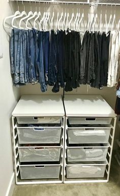 an organized closet with clothes and pants hanging on the rack, drawers are open to reveal jeans