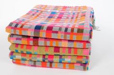 four multicolored towels stacked on top of each other in different sizes and colors