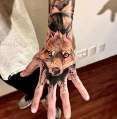 a hand with a wolf tattoo on it