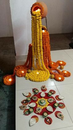 an arrangement of flowers and candles on a table in the middle of a room with lights