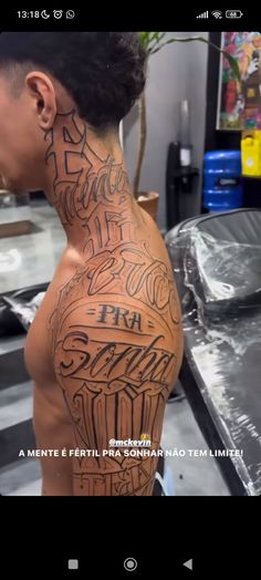 the back of a man's head with tattoos on it and words written in different languages