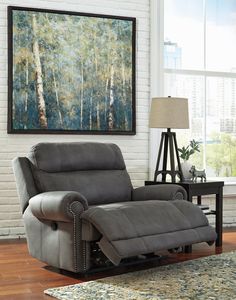 a living room with a recliner and a painting hanging on the wall above it