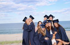 a group of young women standing next to each other on top of a sandy beach