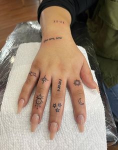 a woman's hand with two small tattoos on it