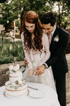 a newly married couple cutting their wedding cake