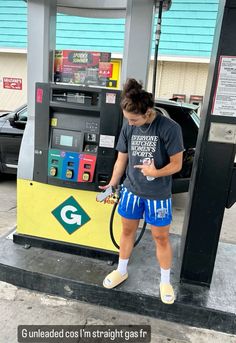 a woman is pumping gas into her car at a gas station in the united states