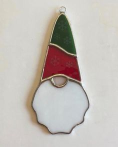 a christmas hat ornament hanging on a white wall with snowflakes in the background