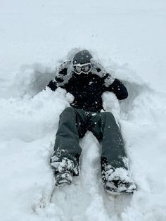 a snowboarder is sitting in the middle of a pile of snow with his feet up