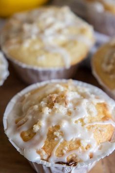 several muffins with icing on a wooden table