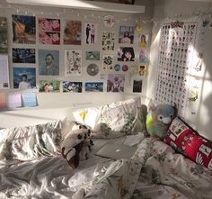 there is a bed with many pictures on the wall and a teddy bear sitting on it