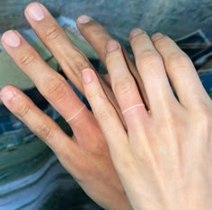 two hands with wedding bands on their fingers