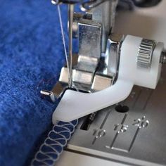 the sewing machine is working on the blue material that has been stitched into it