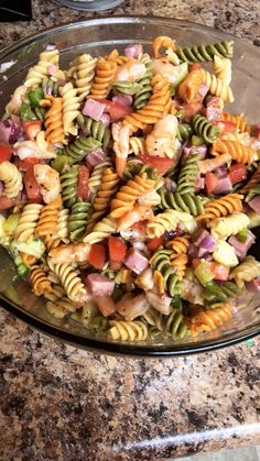 a bowl filled with pasta salad on top of a counter