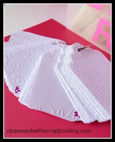 four white doily place cards on a red envelope