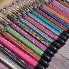 many different colored pens lined up on a table