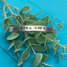 "Anam Cara (Gaelic for soul mate)  and floral details hand stamped on polished aluminum slim cuff with enameled details. Design is inked in black but can be left uncolored or in a different color.  Want to make a change? Let me know what you want to see, and we can create one together =) The Product: **Approx 1/4\" width **Approx 6\" length **Aluminum **Slim cuff  **Black enamel design  I use aluminum for my stamping because it does not rust or tarnish. Aluminum jewelry is lightweight, hypoaller Aluminum Jewelry, Cloth Wipes, Soul Mate, Know What You Want, Hand Stamped Jewelry, Make A Change, Stamped Jewelry, Jewelry Cleaner, Black Enamel