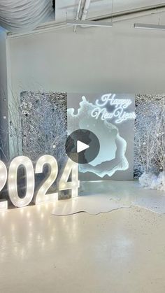 a large white sign sitting in the middle of a room next to snow covered trees