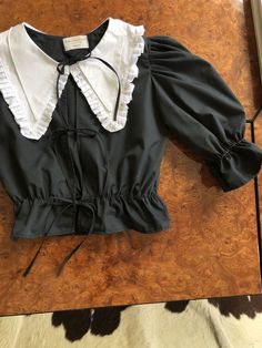 Black Cotton Collared Blouse, Black Ruffled Collar Top, Fitted Black Blouse For Daywear, Casual Black Blouse With Doll Collar, Classic Black Blouse For Daywear, Black Fitted Tops For Daywear, Fitted Black Top For Daywear, Black Doll Collar Top For Spring, Elegant Black Top With Doll Collar