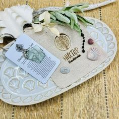 a white plate topped with an open book and seashells on top of it