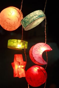 colorful paper lanterns hanging from strings in the dark