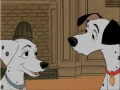 dalmatian looking at another dog in front of a fireplace