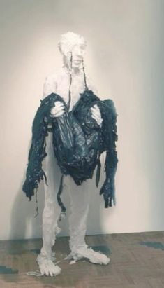 a man is dressed in plastic bags and holding his hands behind his back while standing on the floor