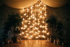 a room with candles and lights in the shape of a christmas tree on the wall