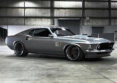 a silver muscle car parked in a garage