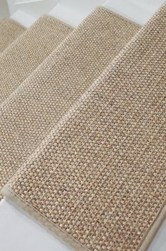 three pieces of natural jute rugs sitting on top of a white countertop