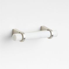 a white toilet paper roll holder on a wall