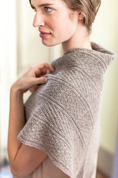 a woman is wearing a shawl over her shoulders