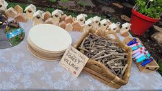 a table topped with lots of different types of wooden sticks and bowls filled with them