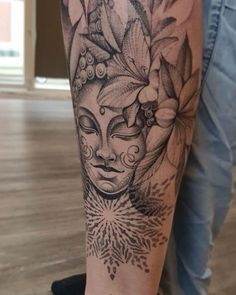 a woman's leg with a tattoo on it that has an image of a face and flowers