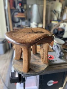 a wooden stool sitting on top of a workbench