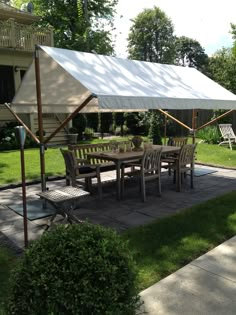 a table and chairs under an awning on a patio