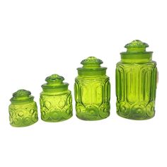 three green glass jars with lids on white background