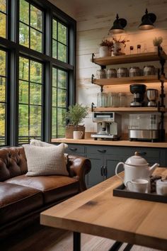 a brown leather couch sitting next to a wooden table in front of a large window