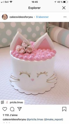 a white cake with pink frosting in a cat shaped box on top of a table